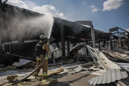 Un bombero trabajando desde el exterior del supermercado destruido, este viernes.