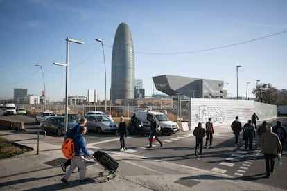 Diverses persones caminen prop de la torre Glòries i l'edifici del Disseny Hub a Barcelona.