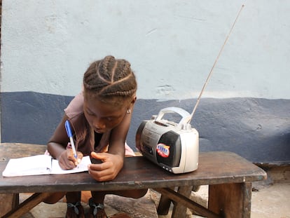 Angela Kamara, de seis años, estudia con ayuda de las clases que está escuchando por radio.