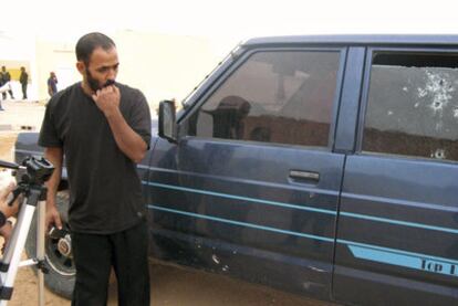 El médico saharaui Hamudi Mojtar, que intentó repeler el asalto, ante un coche tiroteado.
