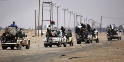 Un convoy de combatientes rebeldes avanza hacia un puente en Ajdabiya.