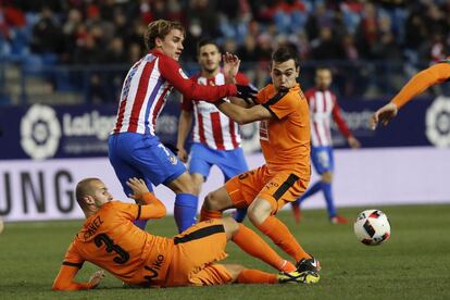 El delantero francés del Atlético de Madrid Antoine Griezmann (c) entre el centrocampista argentino Gonzalo Escalante (d) y el defensa Alejandro Gálvez (i), del Eibar.