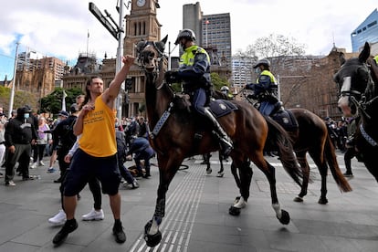 Un manifestante intenta apartar un caballo de la policía durante una manifestación contra las restricciones, en Sídney el 24 de julio.