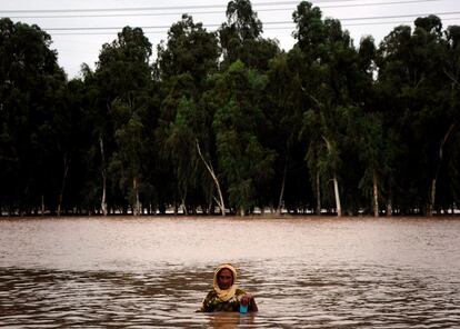 Una mujer intenta cruzar una zona inundada en Chakar Kot, en la provincia de Punjab, Pakistán.