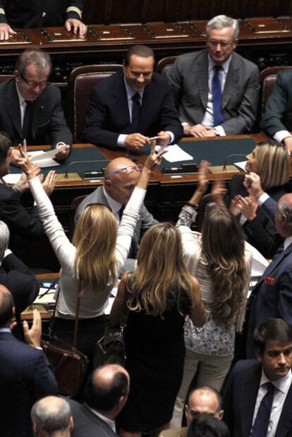 Varias diputadas celebran frente a Silvio Berlusconi la victoria de este en el Parlamento.