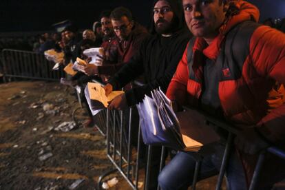 Cientos de refugiados sirios e iraquíes se aseguran un puesto en la cola del registro de la policía para obtener un número de paso. En sus manos, los fajos de papeles que les identifican como refugiados