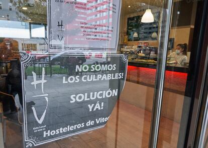 Un bar de Vitoria muestra un cartel en contra del cierre de los establecimientos.