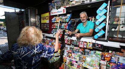 Una mujer compra una revista en un quiosco madrileño.