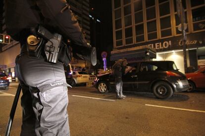 Un policía de la UPR vigila, escopeta en mano, como se desarrolla el control en la calle de Orense.