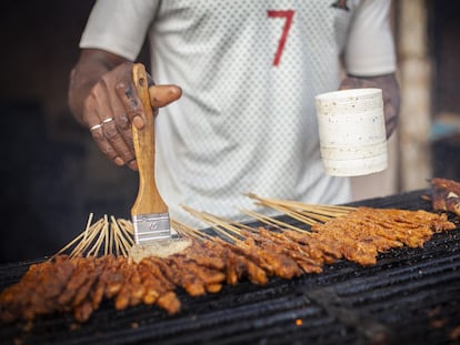 “Estoy aquí desde las 5.30 pm y hasta medianoche", comenta Abdou mientras impregna de aceite las brochetas en la parrilla que vende en las calles de Dakar. Las más populares son las de ternera, dice.