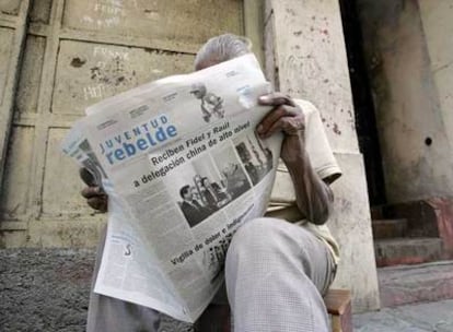 Un hombre lee <i>Juventud Rebelde</i>, que en su primera página muestra una foto del encuentro del viernes entre Castro y Wu Guanzheng.