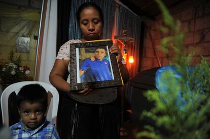 Una familiar del migrante difunto Miguel Rojche Zapalu sostiene una foto enmarcada de él durante su velorio en Nahualá.