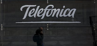 Un viandante pasa por debajo del logo de Telef&oacute;nica