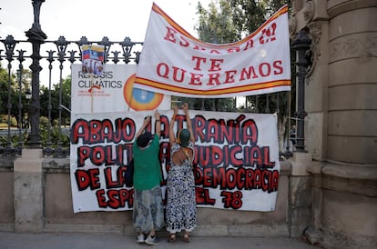 Dos mujeres colocan pancartas contra el independentismo a la entrada del Parlamento catalán, este jueves.