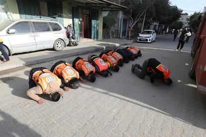 Personal de emergencia y defensa civil rezan para celebrar el alto el fuego en el campo de refugiados de Nuseirat de Ciudad de Gaza, este domingo. 