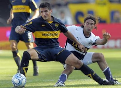 Viatri se lleva el balón ante Rinaudo durante un partido entre el Boca y el Gimnasia.