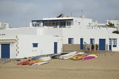 Varios jóvenes junto a unas piraguas en la Caleta del Sebo, situada en la isla de La Graciosa.
 