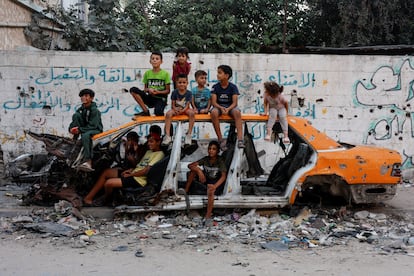 Niños gazatíes posan entre los restos de un coche en Jan Yunis, el 30 de septiembre de 2024.
