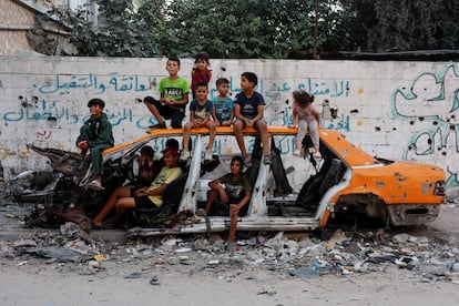 Niños gazatíes posan entre los restos de un coche en Jan Yunis, el 30 de septiembre de 2024. 