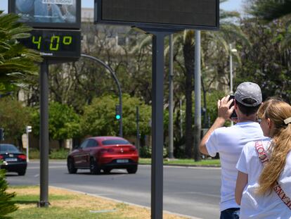Turistas fotografían un termómetro de una calle del centro de Sevilla, este viernes.