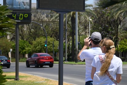 Turistas fotografían un termómetro de una calle del centro de Sevilla, este viernes.