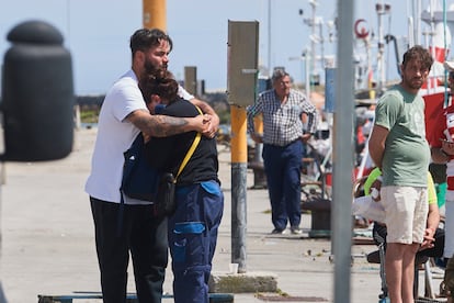 Dos familiares del pescador desaparecido tras caer al mar de su barco de origen gallego, en el puerto de San Vicente de la Barquera, ayer.