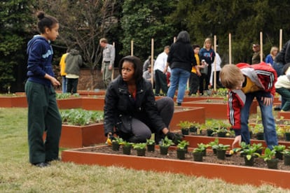 La primera dama estadounidense, Michelle Obama, planta árboles junto a un grupo de niños en el Kitchen Garden, en el Jardín Sur de la Casa Blanca, en Washington.