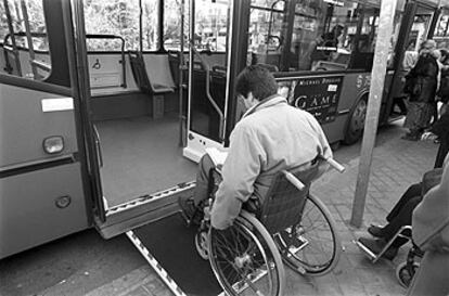 Un discapacitado sube a un autobús en su silla de ruedas, en Madrid.