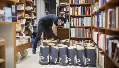 Un treballador prepara paquets de llibres per enviar, a la llibreria Laie.