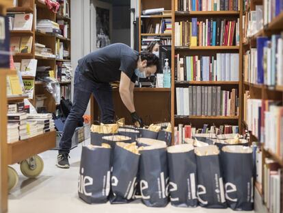 Un treballador prepara paquets de llibres per enviar, a la llibreria Laie.