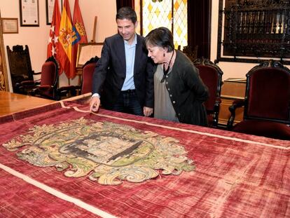 El alcalde de Alcalá, Javier Rodríguez Palacios, y la concejal de patrimonio histórico, Olga García, observando el tapiz del siglo XVII.