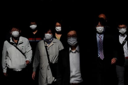 Trabajadores protegidos con mascarillas, en la estación de Shinagawa, en Tokio (Japón).