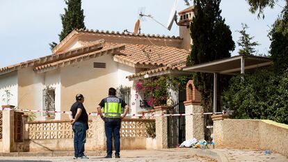Miembros de la Policía Nacional vigilan la entrada a la vivienda del suceso, en Benajarafe (Málaga).
