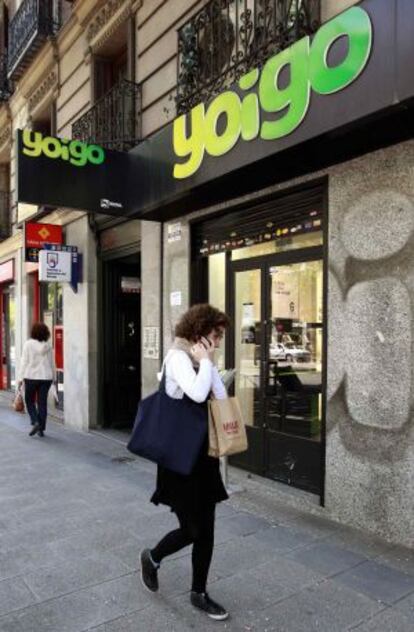 Una mujer pasa por una tienda de Yoigo