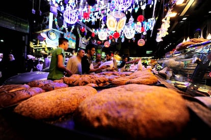 Un grupo de hombres compran en un pastelería callejera de Damasco (Siria) durante el mes de Ramadán.