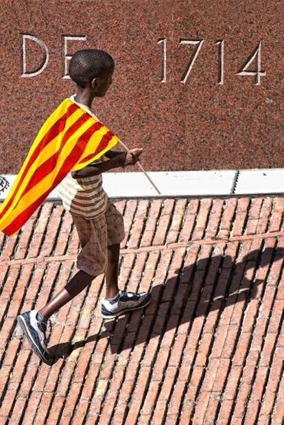 Un niño con una <i>senyera, </i>ayer, durante el acto de CiU en el Fossar de les Moreres.