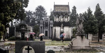 Un grupo de personas camina en el cementerio de Turín, en el norte de Italia, este lunes.