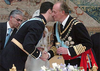 El rey Juan Carlos besa a su hijo, don Felipe, durante el brindis en el banquete celebrado en el Palacio Real.