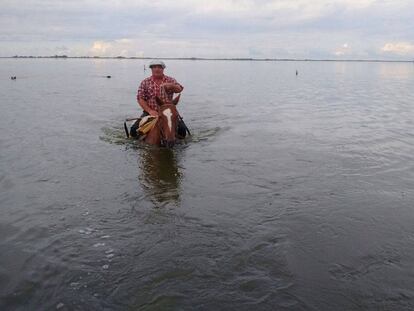 Un hombre a caballo cruza un campo inunado en General Villegas, provincia de Buenos Aires.