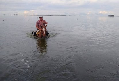 Un hombre a caballo cruza un campo inunado en General Villegas, provincia de Buenos Aires.