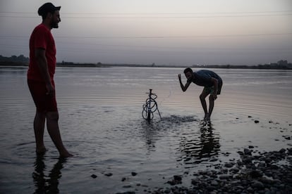 Un grupo de personas pasan un rato descansando y fumando un narguile junto al río Éufrates al atardecer.