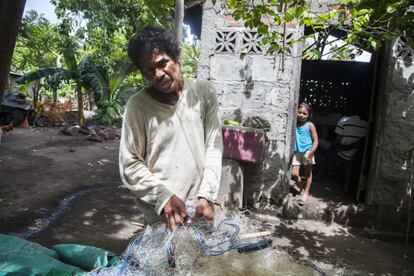 Modesto Leoncio, pescador, con las redes que utiliza en su trabajo, posa en su casa de Esquipulas.