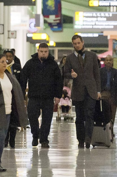 El duque de Palma, Iñaki Urdangarin, junto a un policía judicial en el aeropuerto de Washington, el 3 de enero de 2012