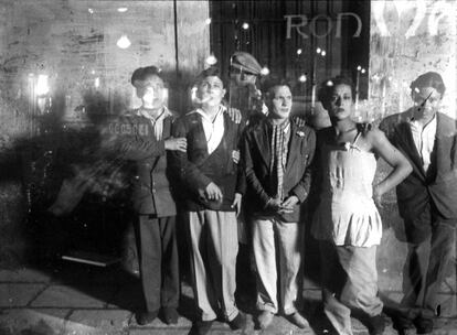 Travestidos en la calle, fotografiados por Gabriel Casas en 1925 a través del vidrio de un bar