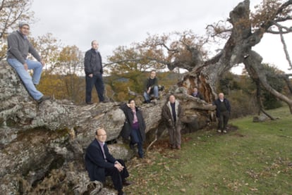 Members of the management committee in La Póveda, Soria, pose with a fallen oak on their redesignated land.