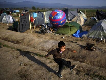 Un ni&ntilde;o juega en un campo de refugiados en la frontera entre Grecia y Macedonia.