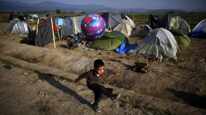 Un ni&ntilde;o juega en un campo de refugiados en la frontera entre Grecia y Macedonia.