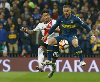 Nahitan Nández de Boca contrala el balón ante Milton Casco de River, durante el partido.