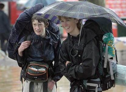 Dos turistas aguantaban ayer la lluvia en el recinto festivo bilbaíno.