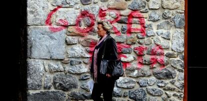 Una mujer camina delante de una pintada en apoyo a ETA en Hernani.